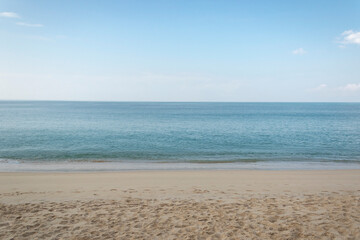 Fototapeta na wymiar View of the sandy beach, summer sea and blue sky.