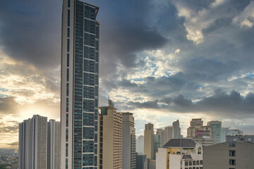 Office building and apartment in Makati City under dramatic cloudy sky