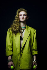 portrait of a woman in yellow coat. Girl keeps a tennis ball. Fashion photo
