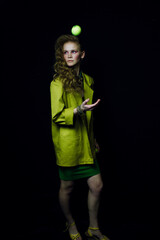 portrait of a woman in yellow coat. Girl keeps a tennis ball. Fashion photo