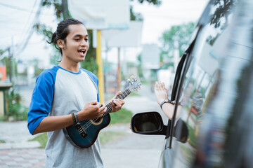 busker sing and use musical instruments when someone refuses to give money by hand gesture from car...