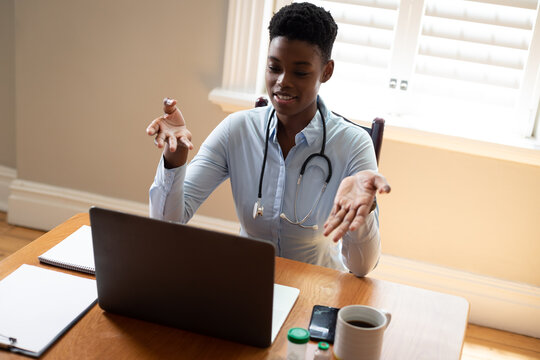 African american female doctor making video consultation call using laptop