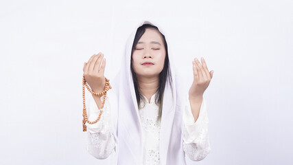 Asian muslim woman wearing prayer beads pray in white background