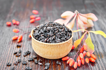 Barberry dried in bowl on dark wooden board