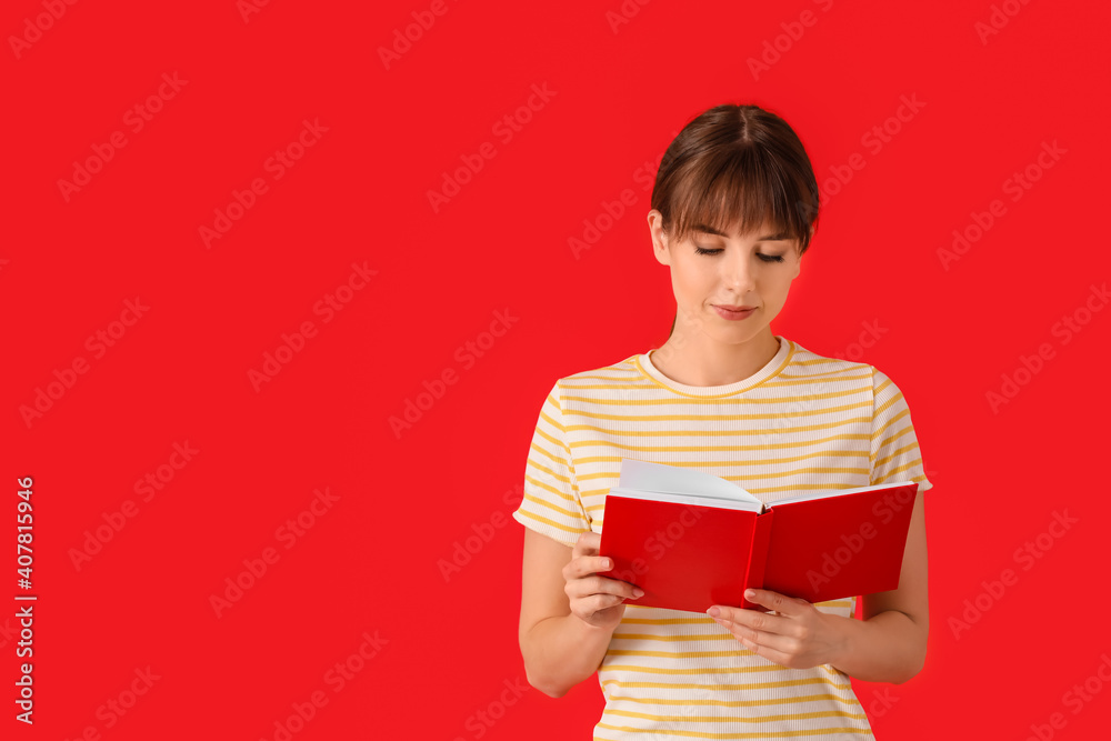 Wall mural beautiful young woman with book on color background