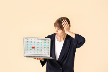 Stressed young woman with laptop on color background. Concept of deadline