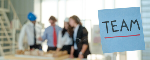 Close up post it note on the glass with business people meeting at the background.