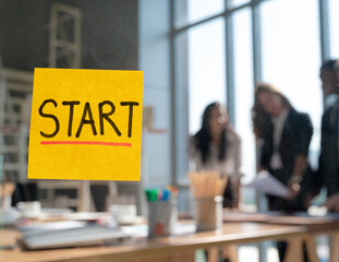 Close up yellow start text post it note on the glass with business people meeting at the background.