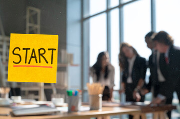 Close up yellow start text post it note on the glass with business people meeting at the background.