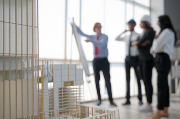 Fototapeta premium Close up building model project on the table with people meeting at the background.