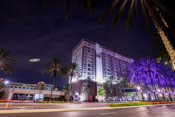 Obraz premium Long exposure night view of traffic passing along a street in downtown Anaheim, California, USA.