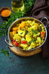 Sabji, Stewed pumpkin with soft cheese and vegetables on a dark stone table. Traditional Indian food. Copy space.