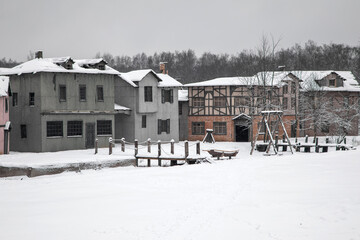 Fototapeta na wymiar A beautiful village of abandoned houses. Winter snowy day. Cloudy sky.