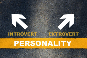Personality written on yellow line with introvert and extrovert with white arrow on asphalt road....