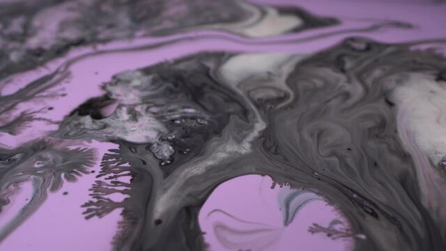 Pastel violet, purple, glitter silver, black and shiny white paints macro. Liquid marble pattern. Abstract background. Fluid acrylic painting
