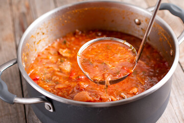 A ladle of borscht. Saucepan with the Ukrainian national dish soup borscht.