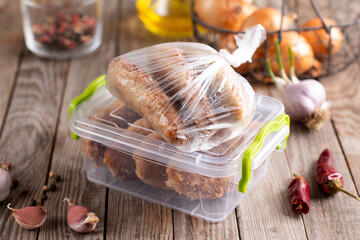 Frozen cutlets in a container and bag. Ready frozen food.