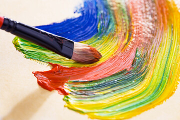 Obraz premium Multi-colored oil paints squeezed out of a tube onto a white sheet of paper.