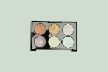 box of highlighter and glitter on green background