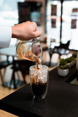 Barista pouring coffee in glass