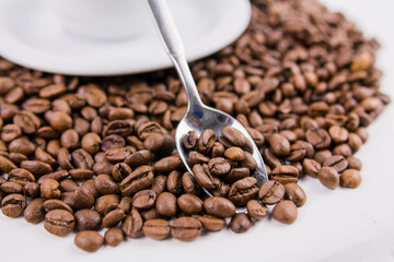 coffee beans in an iron spoon on the table