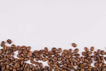 a roasted coffee beans sprinkled on white background