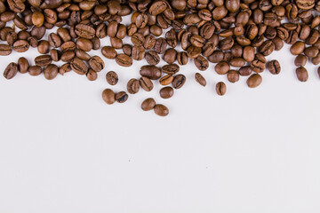 a roasted coffee beans sprinkled on white background