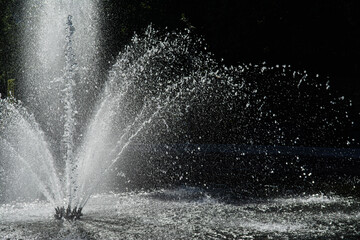 Close-up on the water jet of a round fountain in a park in Brussels. It falls back in large drops,...
