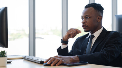 African businessman wearing suit working with computer at the office.