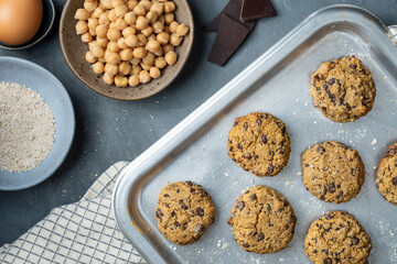Horizontal composition of a baking tray with freshly baked chickpea cookies and dark chocolate chips