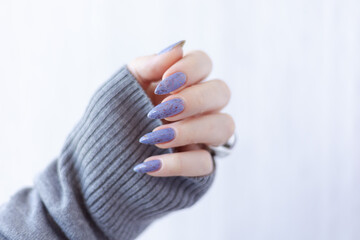 Womans hands with long nails with violet purple nail polish