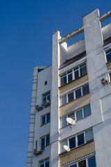 Ground view of apartment building against blue sky.