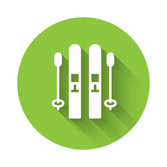 White Ski and sticks icon isolated with long shadow. Extreme sport. Skiing equipment. Winter sports icon. Green circle button. Vector.