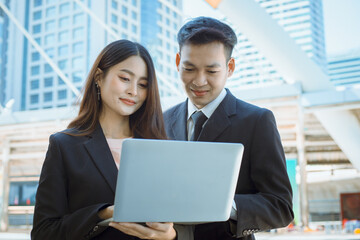 Happy businessman and businesswoman hands hold laptop outdoor.