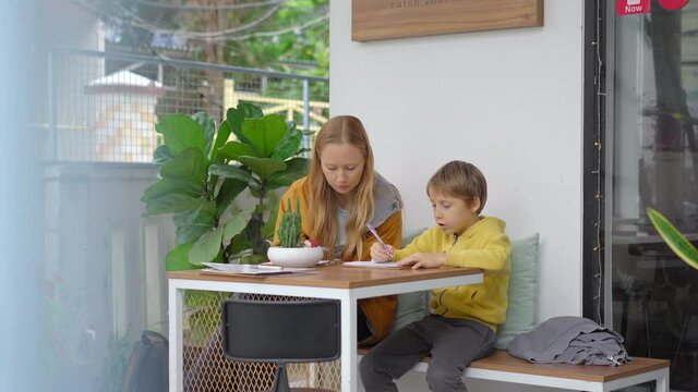 A young woman and her son have a dinner in a beautiful cafe where poke bowls are served. They choose the ingredients for their poke