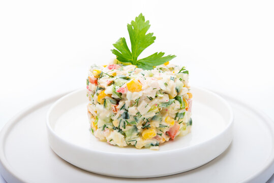 Traditional Russian salad with corn, crab meat and mayonnaise isolated on a white background