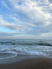 A unique palette of colors and shades of blue barely cloudy sky over the calm azure surf of the Black Sea coast.