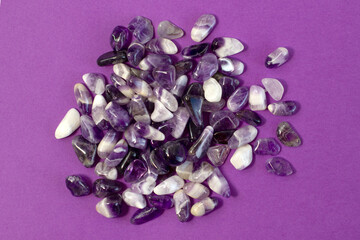 Set of various amethyst natural mineral stones and gemstones on purple background