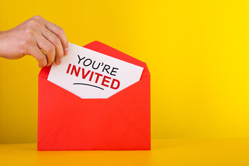 Hand holding a a card with red envelope - You're Invited Concepts