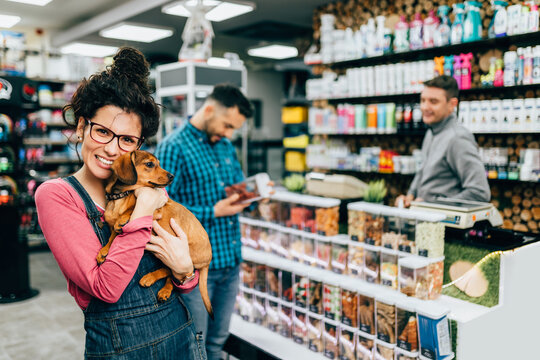 Customers buying accessories and food for their pet in pet shop.