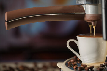 Close-up of espresso pouring from coffee machine. White coffee cup, coffee beans. Coffee foam overflows from a cup