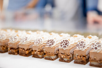 Close-ups of row cake buttercream brownies on display catering sweet table decoration mats