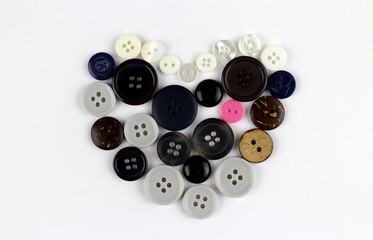 Heart made of multi-colored buttons of different sizes on a white background