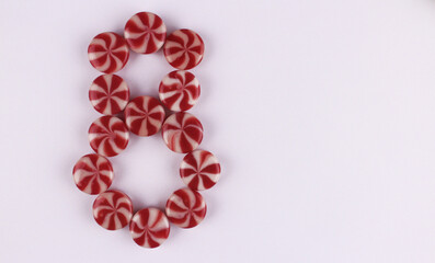 Obraz premium Eight of sweet red and white candies. Eight for women's day on March 8