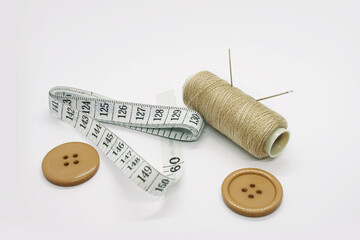 Sewing accessories. Threads, needles, tape measure, buttons, pins. Close-up. White background. Hobby. Needlework. Sewing