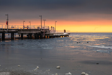 Wooden pier in Jastarnia village on Hel Peninsula at sunset time. Winter landscape. Poland.