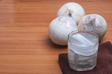 Fresh coconut juice with coconut white meat on wooden background