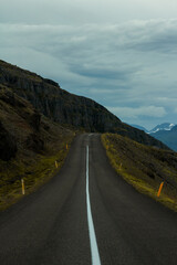 A long road leading through big mountains. Icelandic road 1 leading through the eastern fjords.