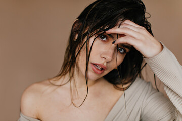 Sensual woman touching black hair. Close-up shot of emotional female model.