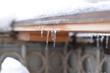 Small transparent icicles with air bubbles inside and water droplets at the tips close-up
